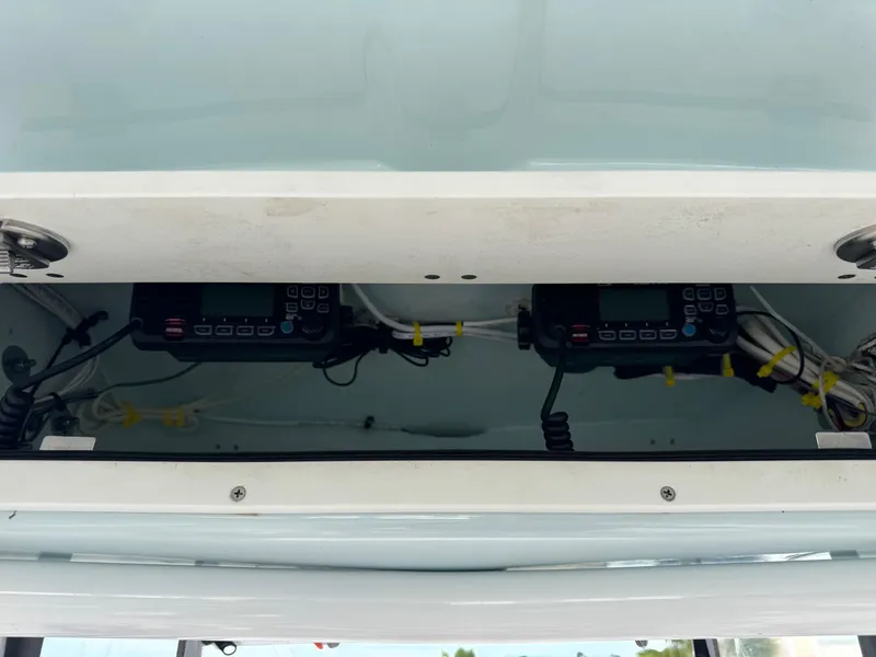 Slide: The Image of 2020 Robalo R222 Center Console electronics compartment with communication devices and wiring. - 10