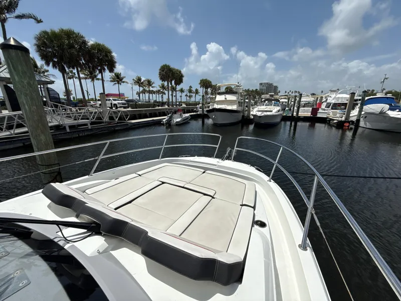 Slide: The Image of 2022 Jeanneau Leader 10.5 WA Series 2 docked at marina, surrounded by palm trees and boats. - 23