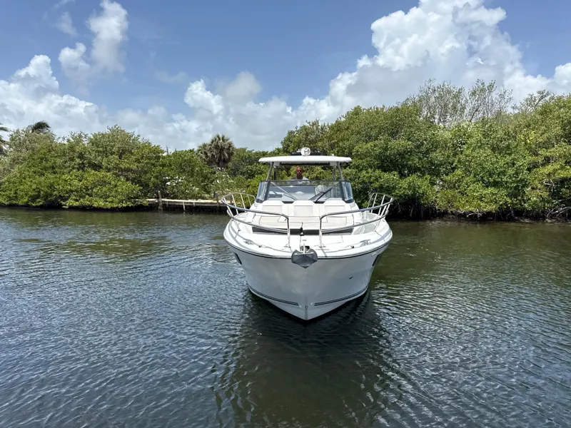 Slide: The Image of 2022 Jeanneau Leader 10.5 WA Series 2 boat on calm water, surrounded by lush greenery. - 9