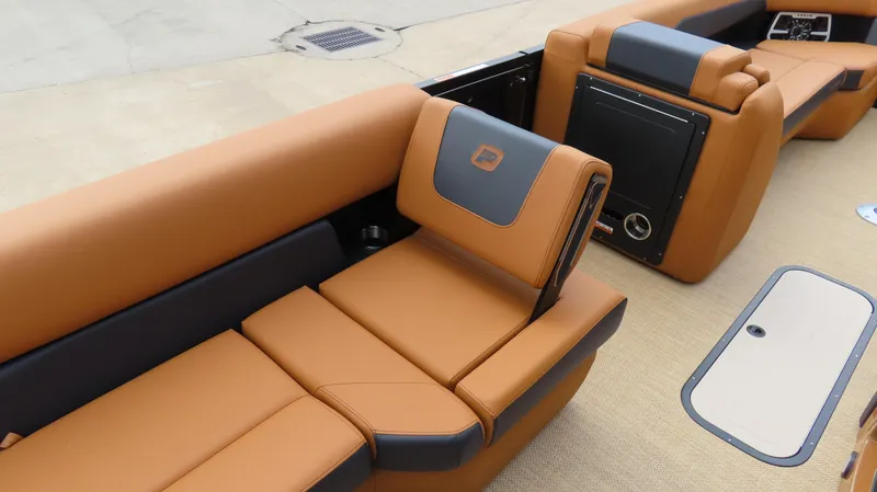 Slide: The Image of Luxurious seating on 2025 Princecraft Vogue 27 RL pontoon boat, featuring tan and black upholstery. - 12