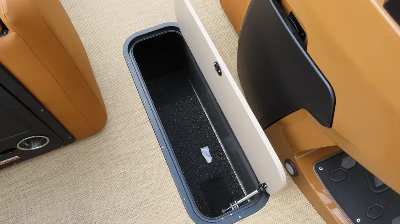 Slide: The Image of Storage compartment in 2025 Princecraft Vogue 27 RL boat, featuring tan upholstery and black interior. - 15
