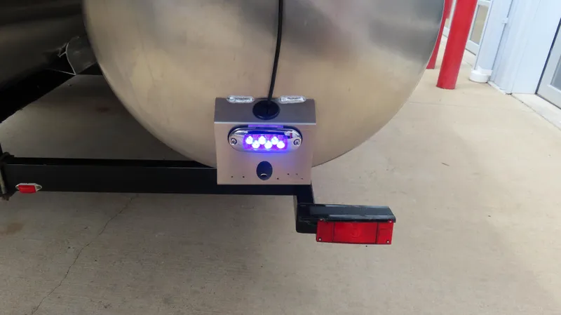 Slide: The Image of 2025 Princecraft Vogue 27 RL pontoon trailer with illuminated rear light and metal frame. - 24