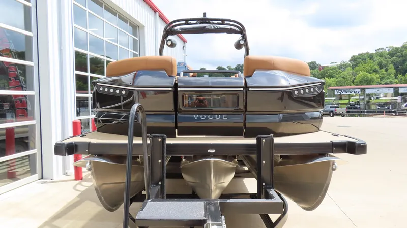 Slide: The Image of 2025 Princecraft Vogue 27 RL pontoon boat on trailer, parked outside a building. - 3