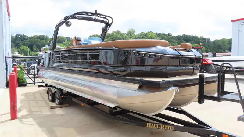 Slide: The Image of 2025 Princecraft Vogue 27 RL pontoon boat on trailer, sleek design, parked outdoors. - 4