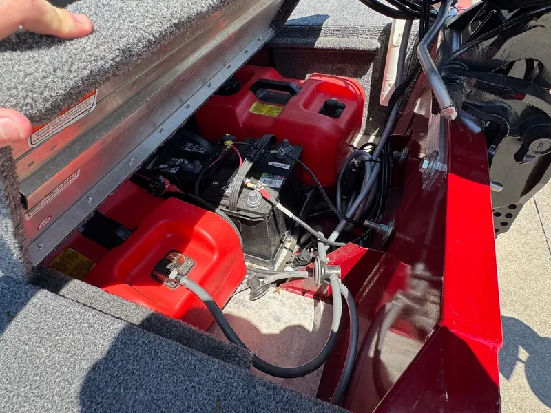 Slide: The Image of 2020 Bass Tracker Classic 16 boat battery compartment with red fuel tanks and wiring. - 15