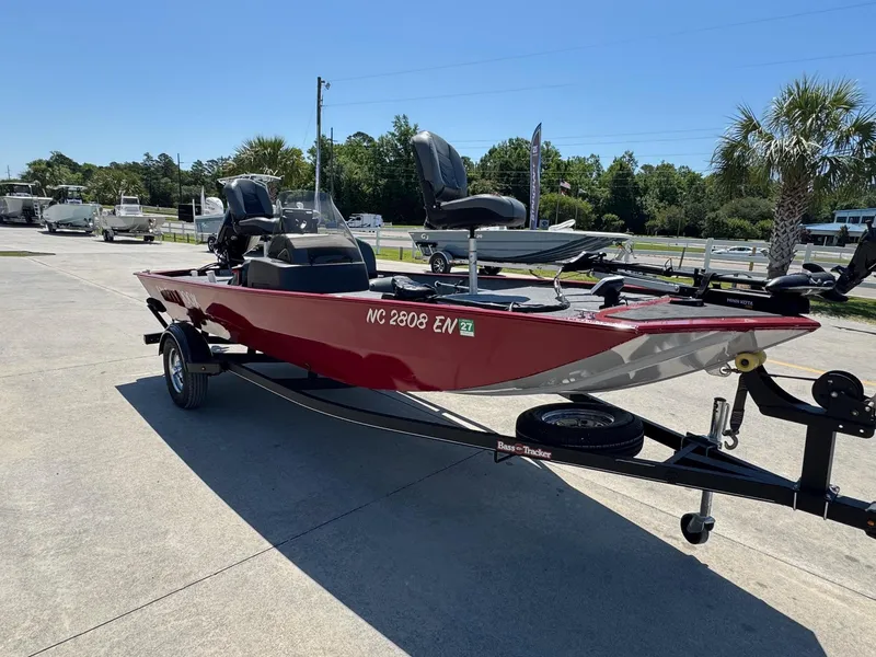 Slide: The Image of 2020 Bass Tracker Classic 16 boat on trailer, parked outdoors under clear sky. - 4