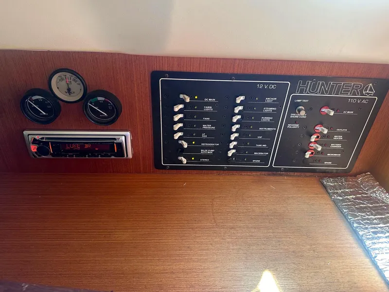 Slide: The Image of Electrical control panel of a 1997 Hunter 310 boat with gauges and stereo system. - 12