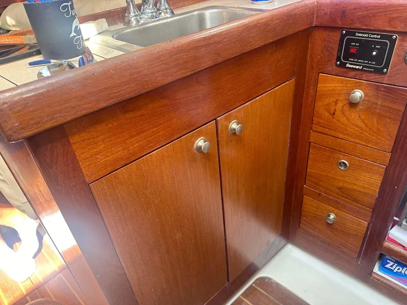 Slide: The Image of Wooden kitchen cabinetry and sink in a 1997 Hunter 310 boat interior. - 16