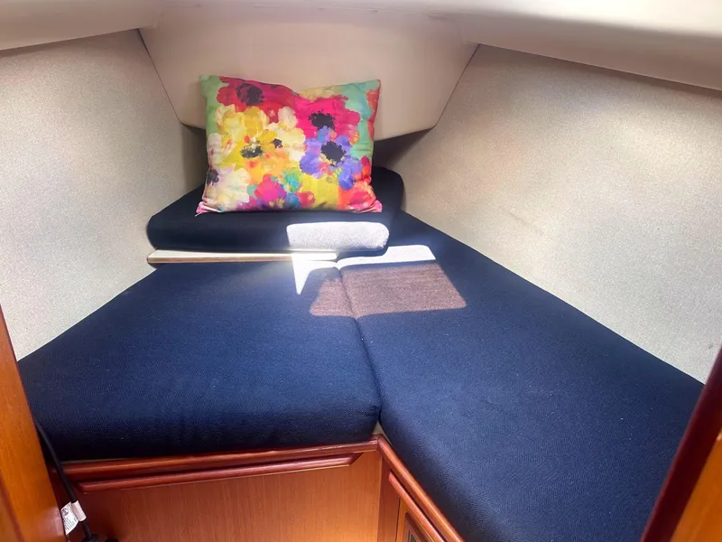Slide: The Image of Cozy cabin interior of 1997 Hunter 310 sailboat with colorful pillow and navy cushions. - 6