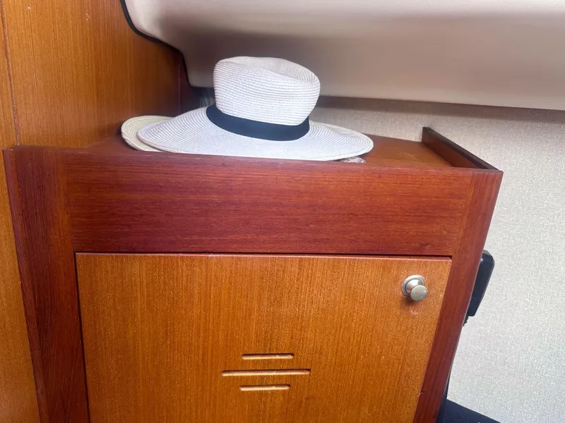 Slide: The Image of White hat on wooden cabinet inside 1997 Hunter 310 sailboat. - 7