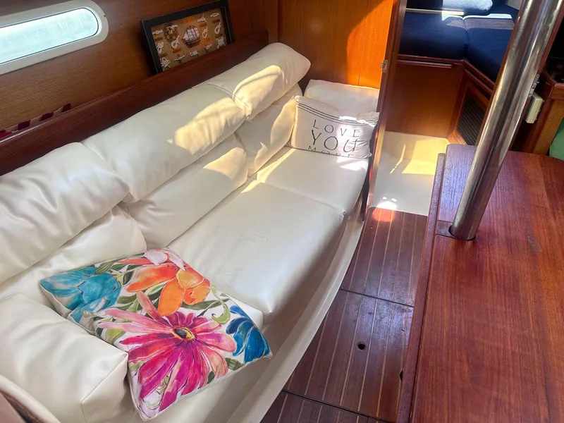 Slide: The Image of Interior of a 1997 Hunter 310 sailboat with cozy seating and decorative pillows. - 8