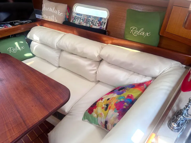 Slide: The Image of Cozy interior of a 1997 Hunter 310 sailboat with plush seating and colorful cushions. - 9