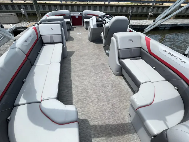 Slide: The Image of 2022 Bennington 22SSRCX pontoon boat with spacious seating and modern design at a dock. - 10