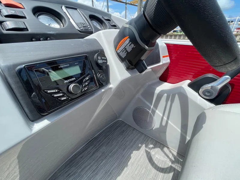 Slide: The Image of 2022 Bennington 22SSRCX boat dashboard with steering wheel and audio controls. - 16