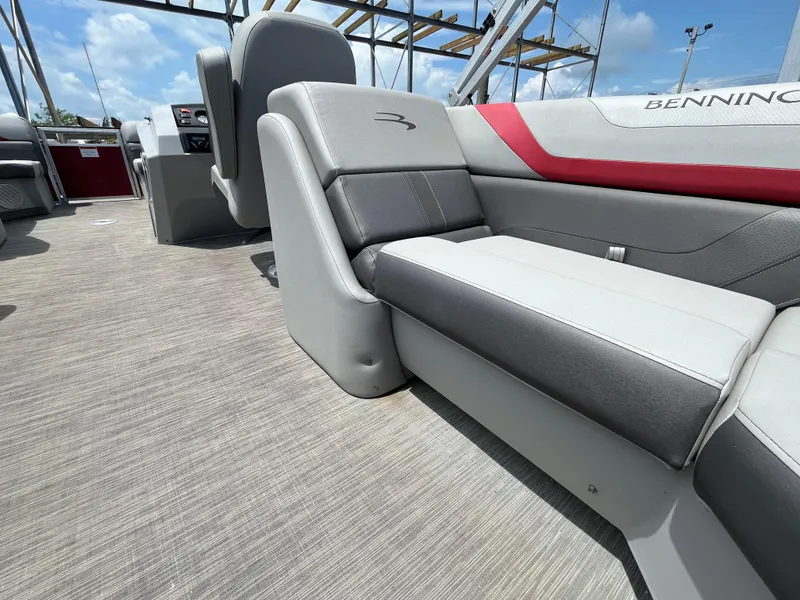 Slide: The Image of 2022 Bennington 22SSRCX boat interior with gray and red seating under blue sky. - 20