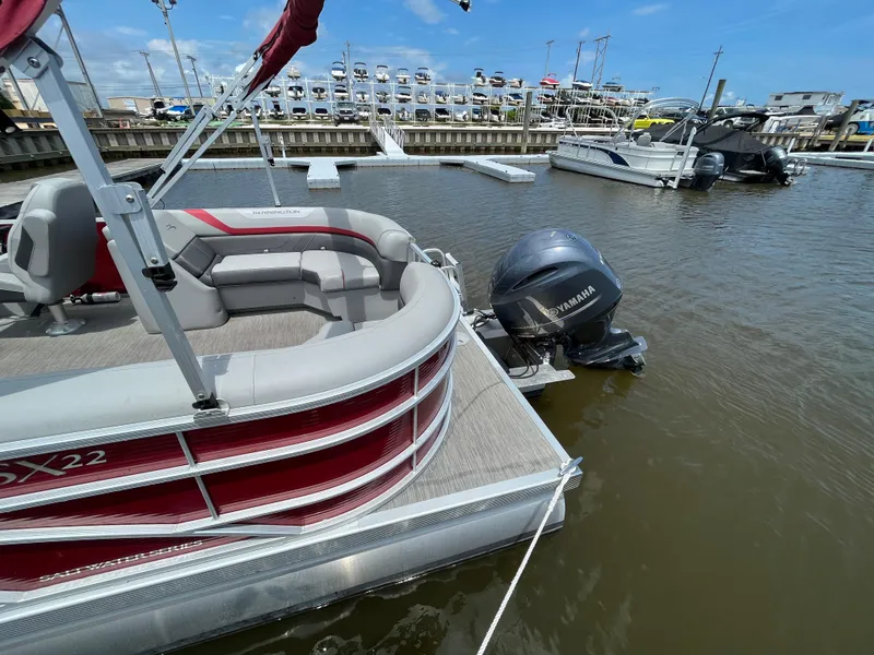 Slide: The Image of 2022 Bennington 22SSRCX pontoon boat docked with Yamaha outboard motor. - 7