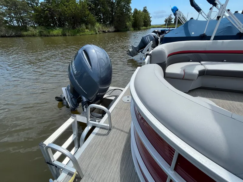 Slide: The Image of 2022 Bennington 22SSRCX pontoon boat with Yamaha outboard motor on a calm river. - 9