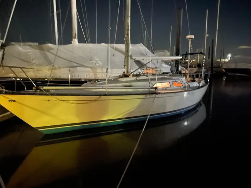 Slide: The Image of 1981 C&C 37 sailboat docked at night, illuminated by soft lighting. - 10