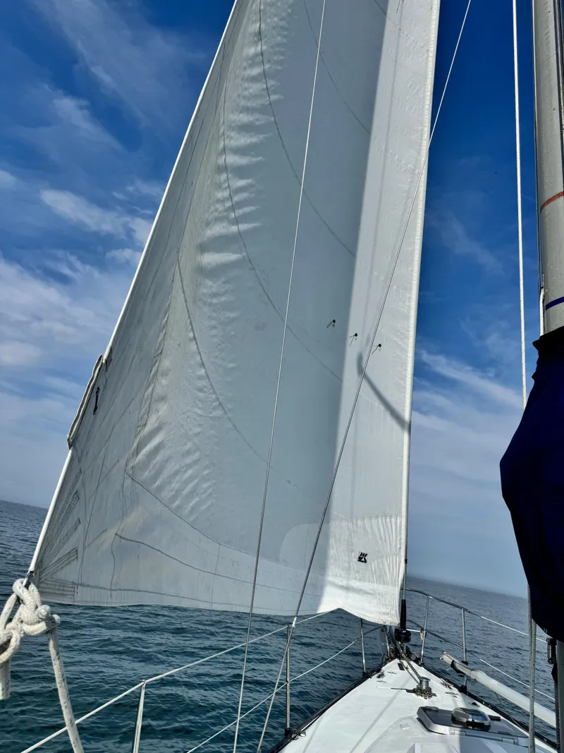 Slide: The Image of Sailing on a 1981 C&C 37 yacht with white sails against a blue sky. - 12