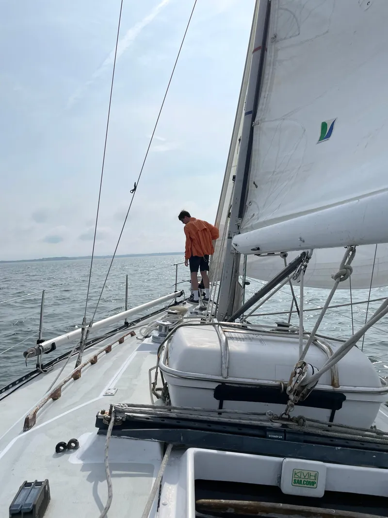 Slide: The Image of Person on deck of 1981 C&C 37 sailboat, sailing on calm waters. - 13