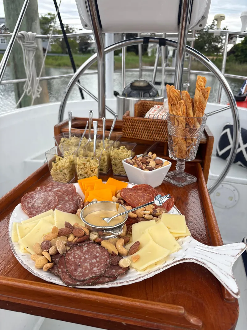 Slide: The Image of Charcuterie board with meats, cheeses, and nuts on a 1981 C&C 37 sailboat. - 18