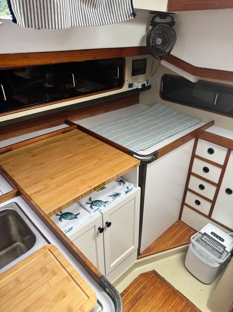 Slide: The Image of Interior of 1981 C&C 37 sailboat kitchen with wooden countertops and compact design. - 23