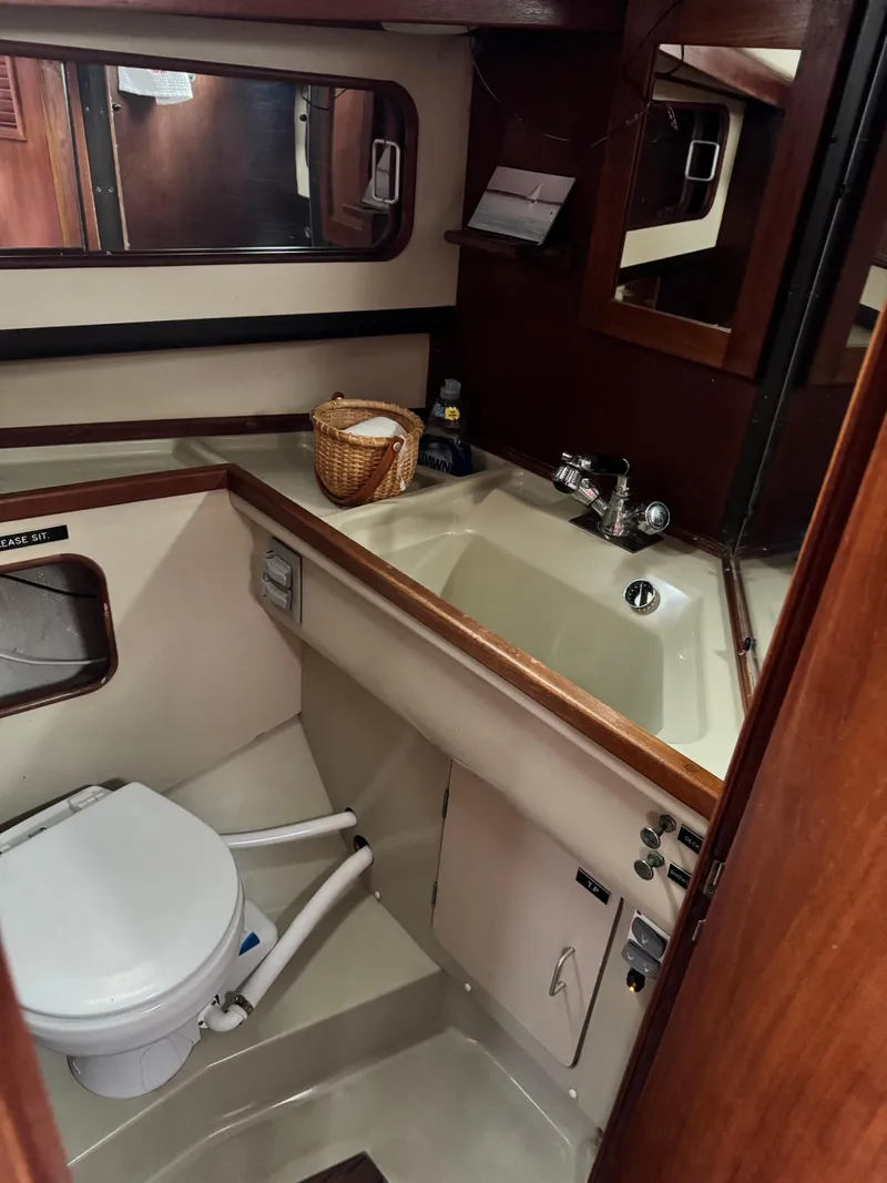 Slide: The Image of 1981 C&C 37 yacht bathroom with sink, toilet, and wooden cabinetry. - 34