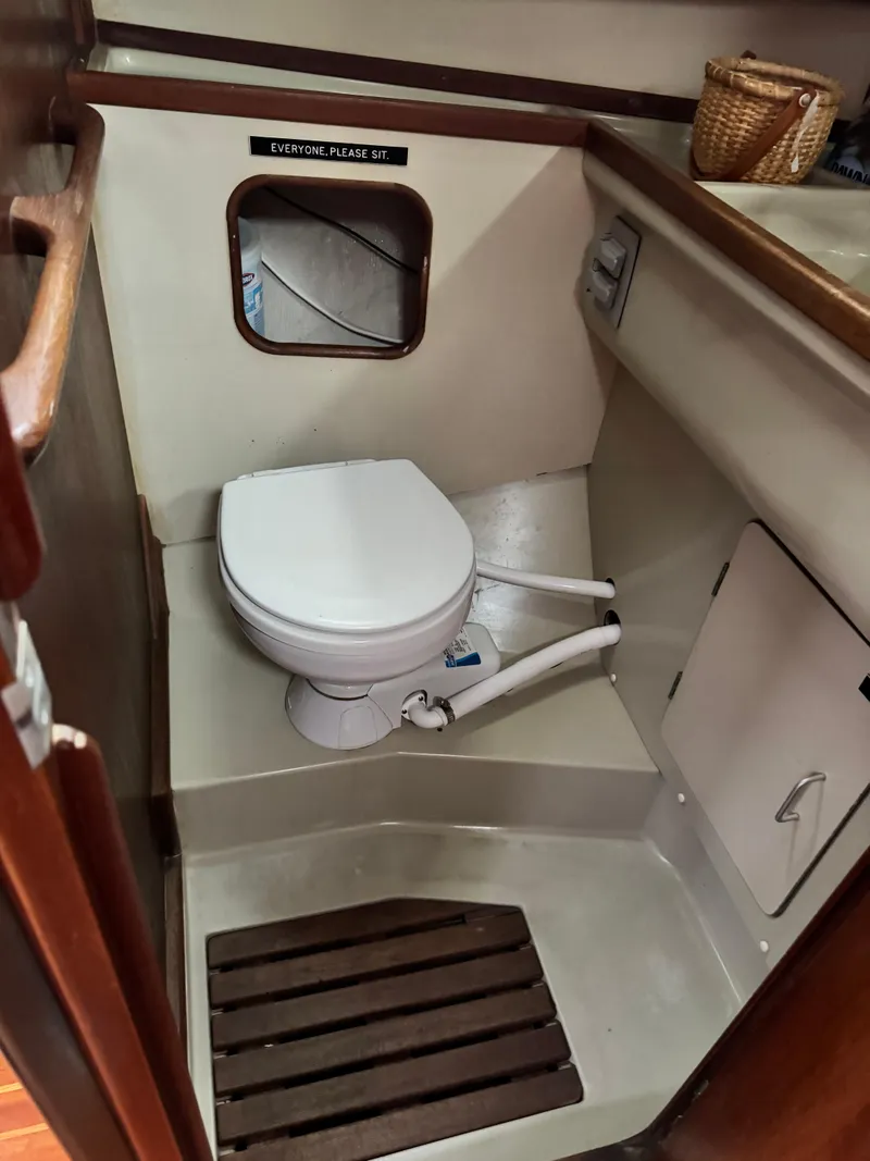 Slide: The Image of 1981 C&C 37 sailboat bathroom with toilet, wooden floor, and storage cabinet. - 36