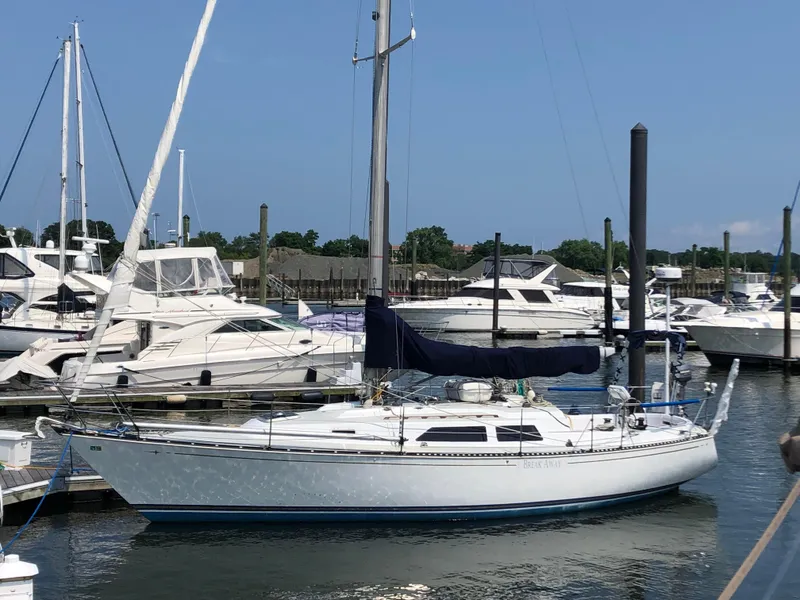 Slide: The Image of 1981 C&C 37 sailboat docked in a marina, surrounded by other boats. - 4