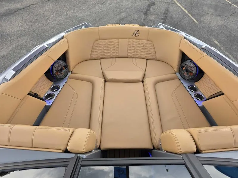 Slide: The Image of Luxurious tan seating in 2025 MasterCraft X24 boat, featuring cup holders and speakers. - 12