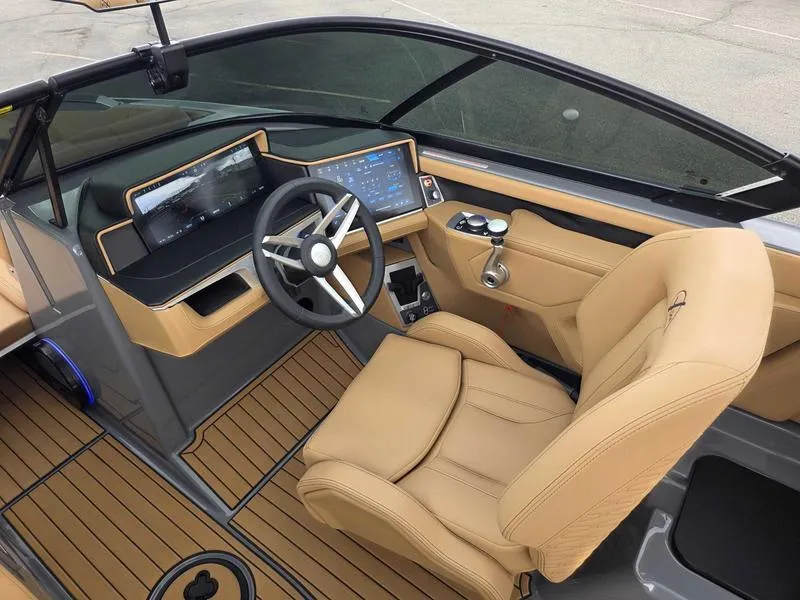 Slide: The Image of 2025 MasterCraft X24 boat interior with modern dashboard and tan leather seating. - 14