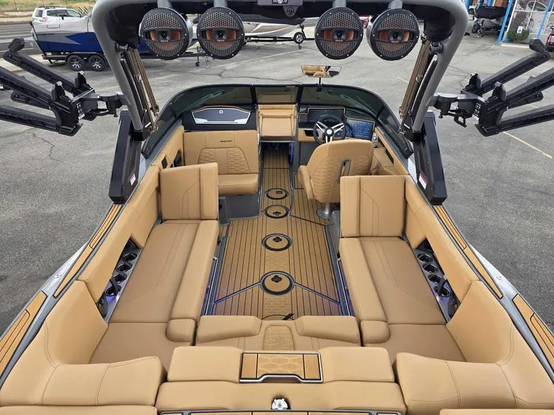 Slide: The Image of 2025 MasterCraft X24 boat interior with tan seating, advanced audio system, and sleek design. - 16