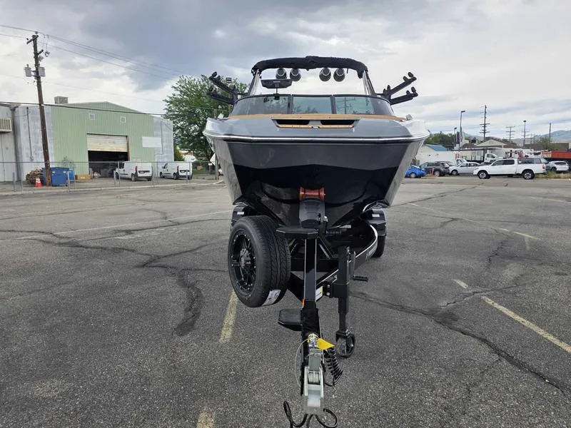 Slide: The Image of 2025 MasterCraft X24 boat on trailer in industrial parking lot. - 2