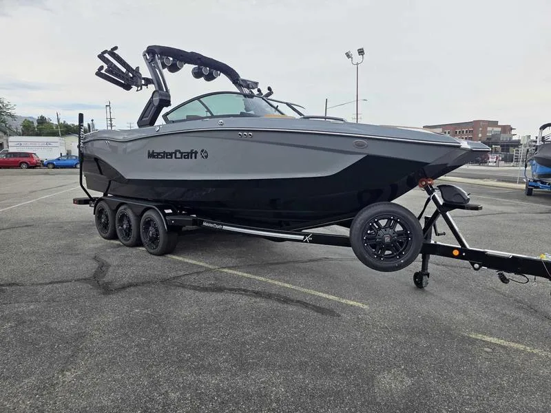 Slide: The Image of 2025 MasterCraft X24 boat on trailer in parking lot, showcasing sleek design and modern features. - 3
