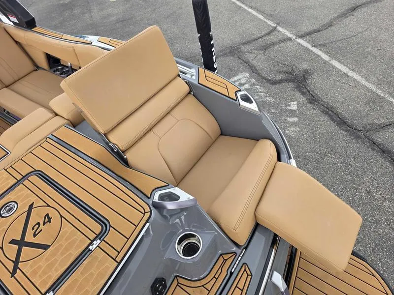 Slide: The Image of 2025 MasterCraft X24 boat interior with tan seating and teak-style flooring. - 5