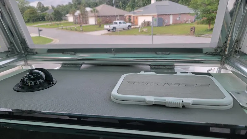 Slide: The Image of 2023 Twin Vee 260 CC GF boat dashboard with compass and branded panel. - 11