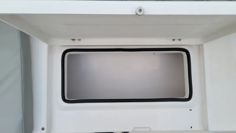 Slide: The Image of Storage compartment of 2023 Twin Vee 260 CC GF boat, featuring a secure latch. - 16