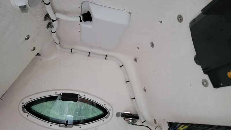 Slide: The Image of Interior view of 2023 Twin Vee 260 CC GF boat, showing wiring and porthole. - 19