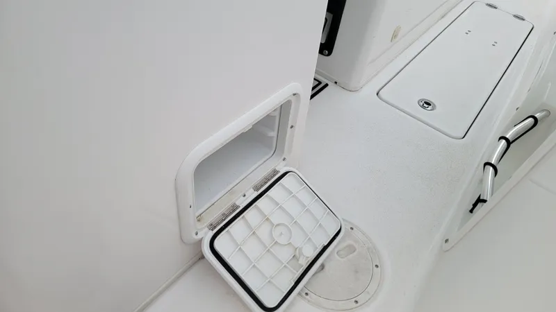 Slide: The Image of 2023 Twin Vee 260 CC GF boat deck with open storage compartment and handle. - 24