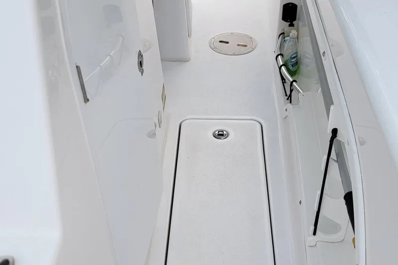 Slide: The Image of 2023 Twin Vee 260 CC GF boat interior, featuring storage compartments and clean white deck. - 26