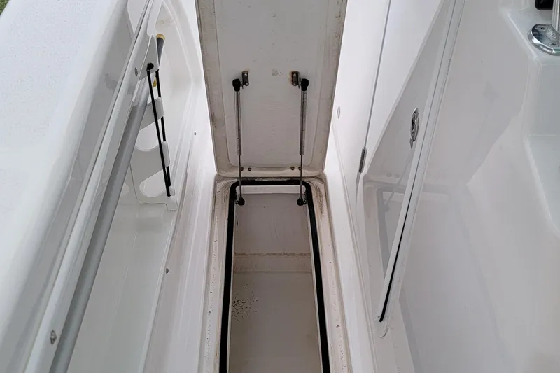 Slide: The Image of 2023 Twin Vee 260 CC GF boat storage compartment, open lid, white interior. - 27