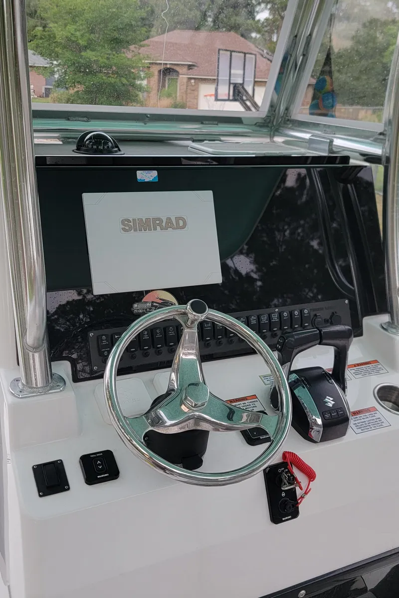 Slide: The Image of 2023 Twin Vee 260 CC GF boat dashboard with Simrad display and steering wheel. - 32