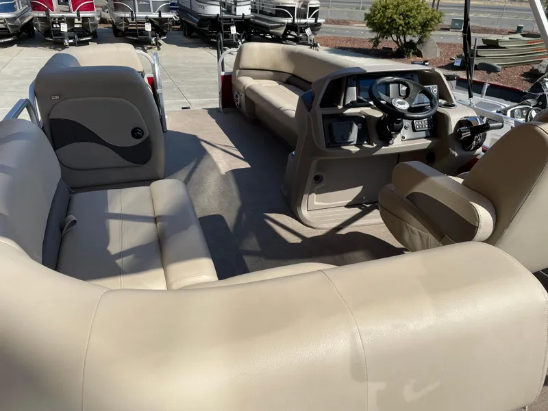 Slide: The Image of 2024 Sun Tracker Party Barge 18 DLX interior with beige seating and steering console. - 4