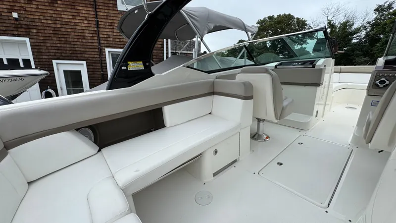 Slide: The Image of 2013 Sea Ray 270 SLX boat interior with white seating and modern dashboard. - 13