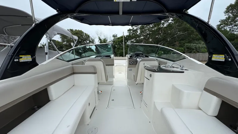 Slide: The Image of 2013 Sea Ray 270 SLX boat interior with seating and helm, under a canopy. - 15