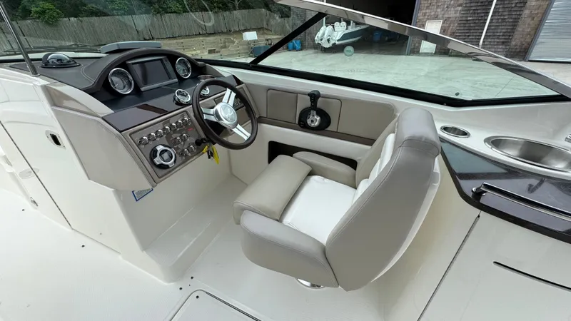 Slide: The Image of 2013 Sea Ray 270 SLX boat cockpit with steering wheel, dashboard, and seating. - 19