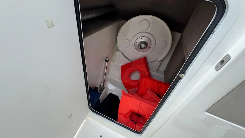 Slide: The Image of Storage compartment on 2013 Sea Ray 270 SLX boat with life jackets and equipment. - 23