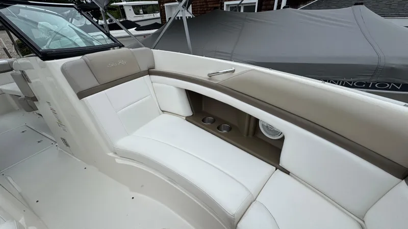 Slide: The Image of 2013 Sea Ray 270 SLX boat interior with white and beige seating, cup holders, and speaker. - 29