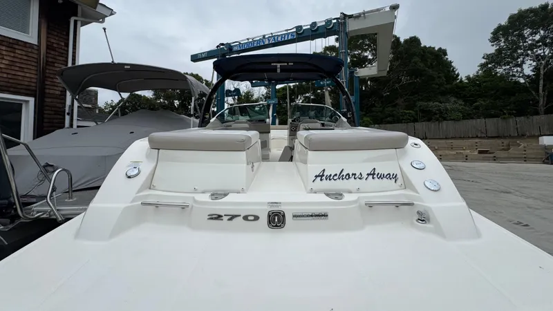 Slide: The Image of 2013 Sea Ray 270 SLX boat with "Anchors Away" text, docked near a building. - 6