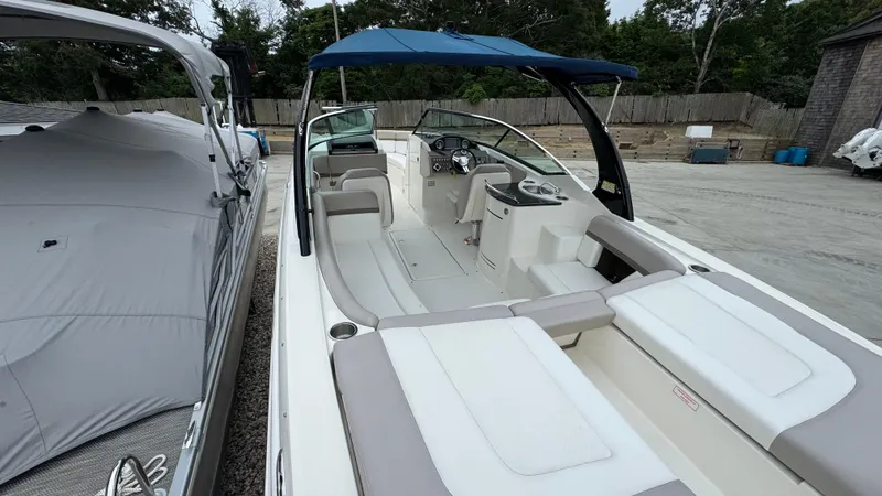 Slide: The Image of 2013 Sea Ray 270 SLX boat with blue canopy, docked outdoors. - 7